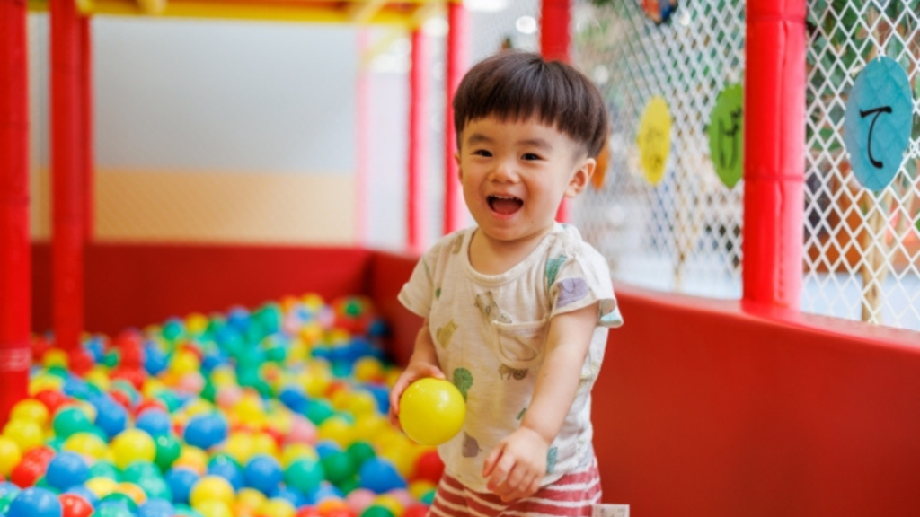 ボールの部屋で右手にボールをつかんだ子どもの様子